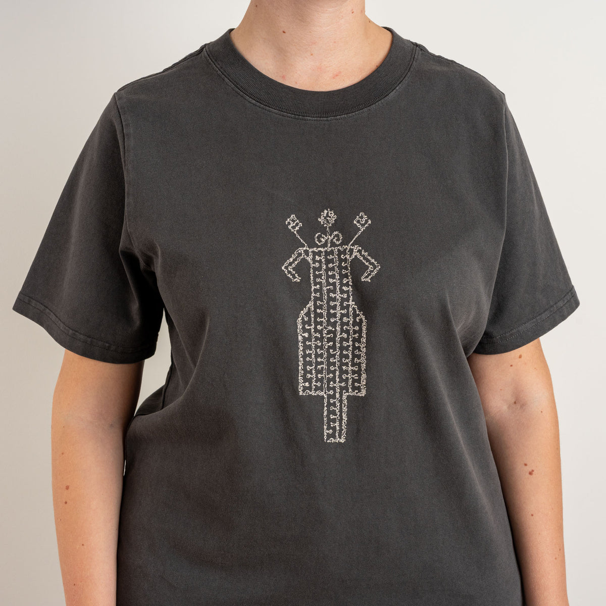 Cream horse-and-rider embroidery on the front of The Ward Faded Black T-shirt, with wide ribbed crew neck, embroidered in Gordina's Netherlands studio.