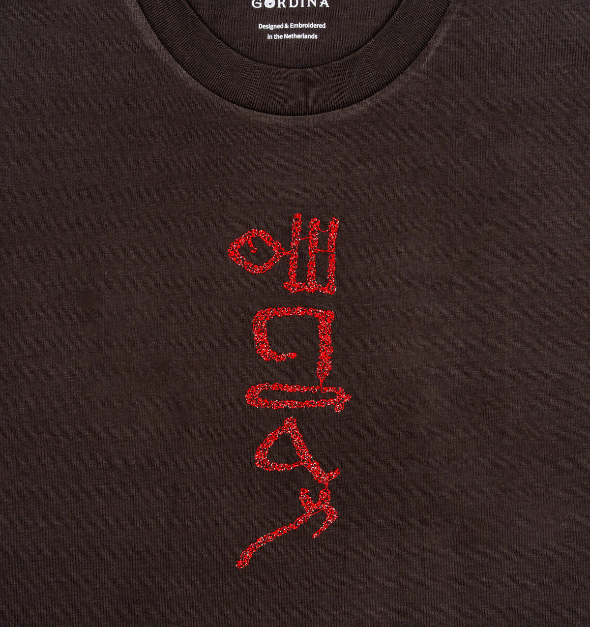 Close-up of hieroglyphic-style embroidery on The Papyrus coal T-shirt