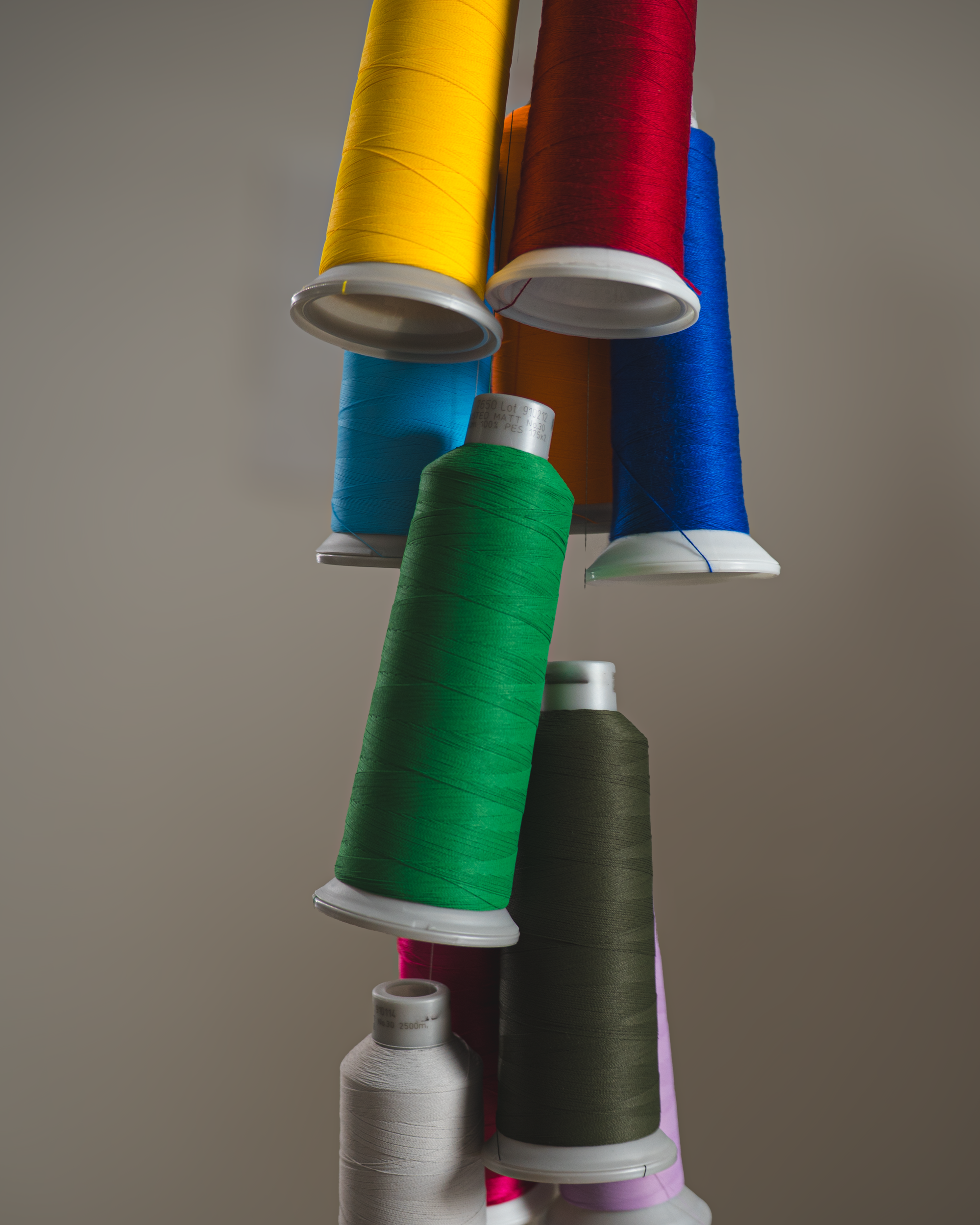 Embroidery thread spools in multiple colors used for Gordina embroidered t-shirt designs and textile production