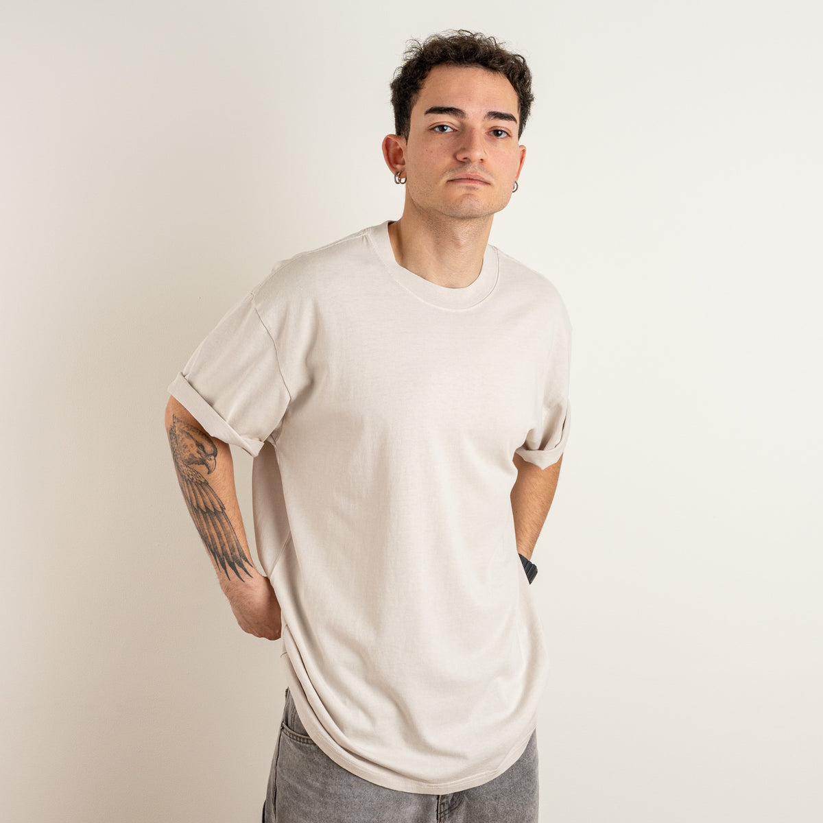 Front view of a model wearing the Gordina Unsigned Faded Beige heavyweight cotton T-shirt, embroidered in the Netherlands.