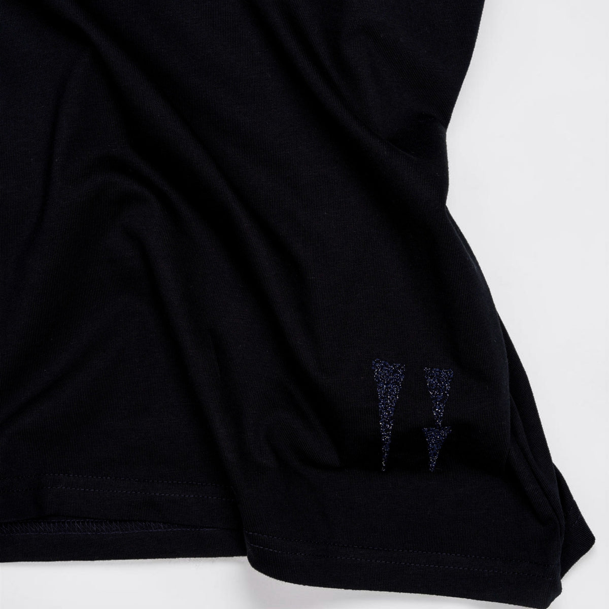 Close-up of the navy cotton and water sign embroidery at the hem.