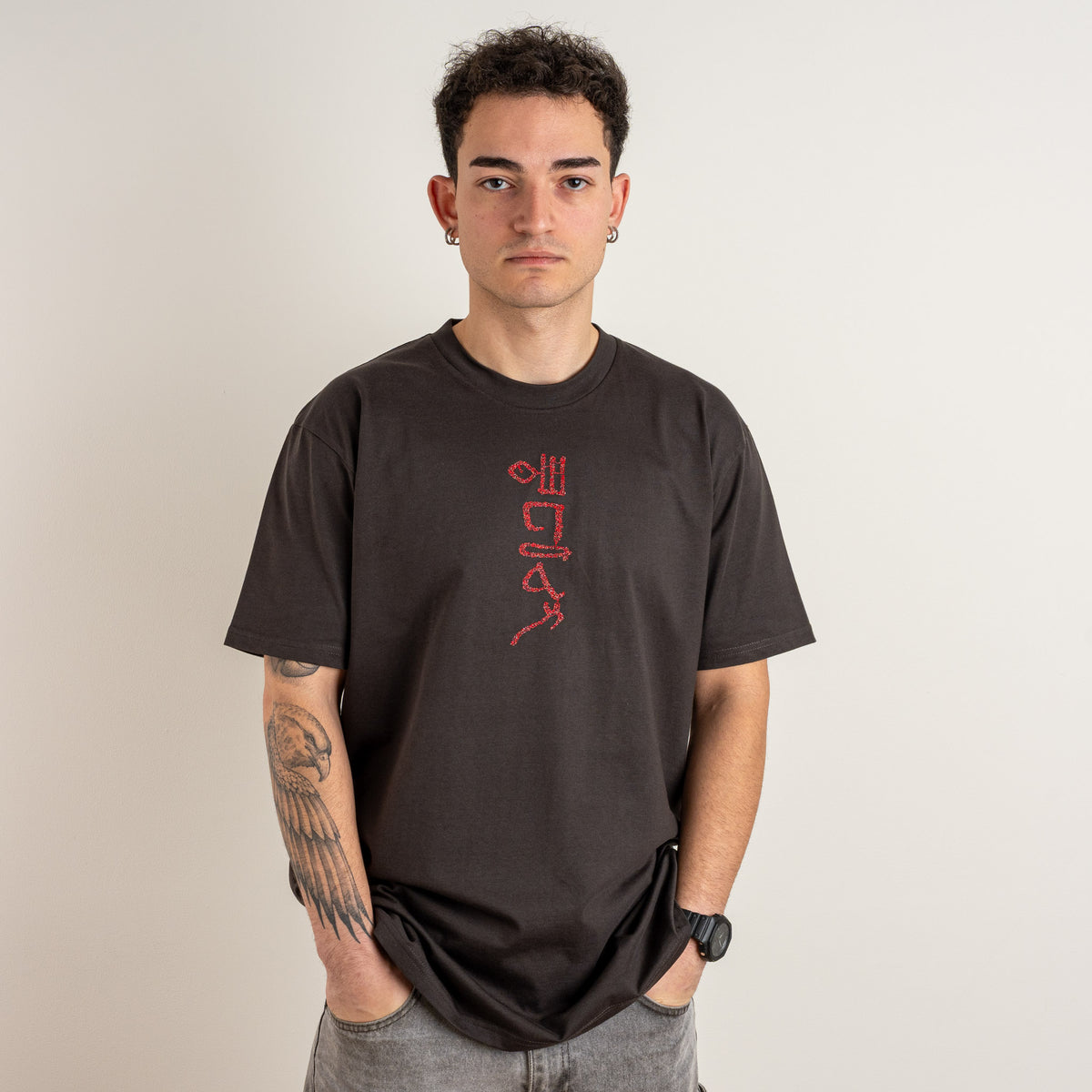 Model wearing the Papyrus coal T-shirt with red embroidery, front view