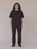 Male model wearing Gordina The Scarab black T-shirt with red embroidery.