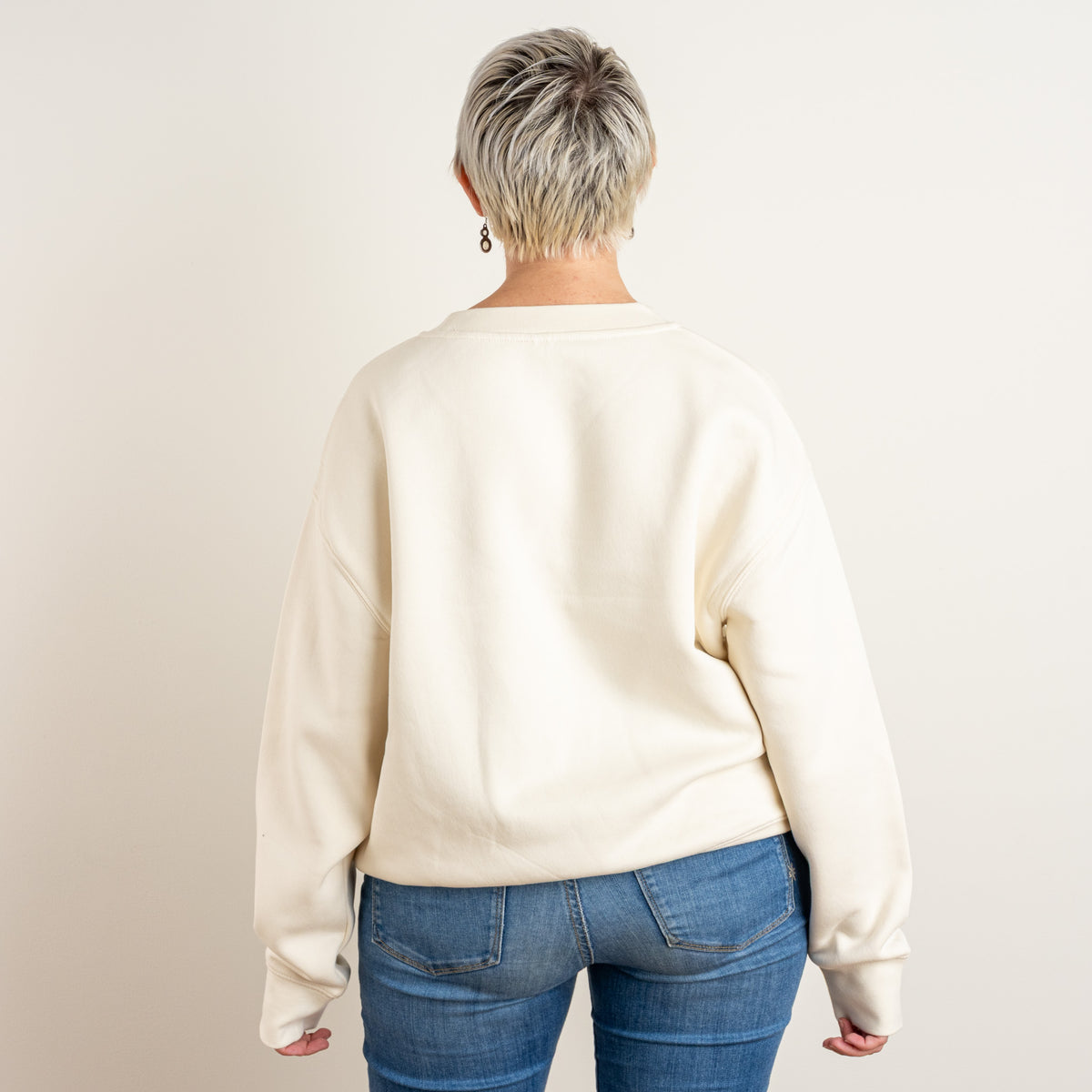 Back view of the ecru Star and House sweatshirt on a model