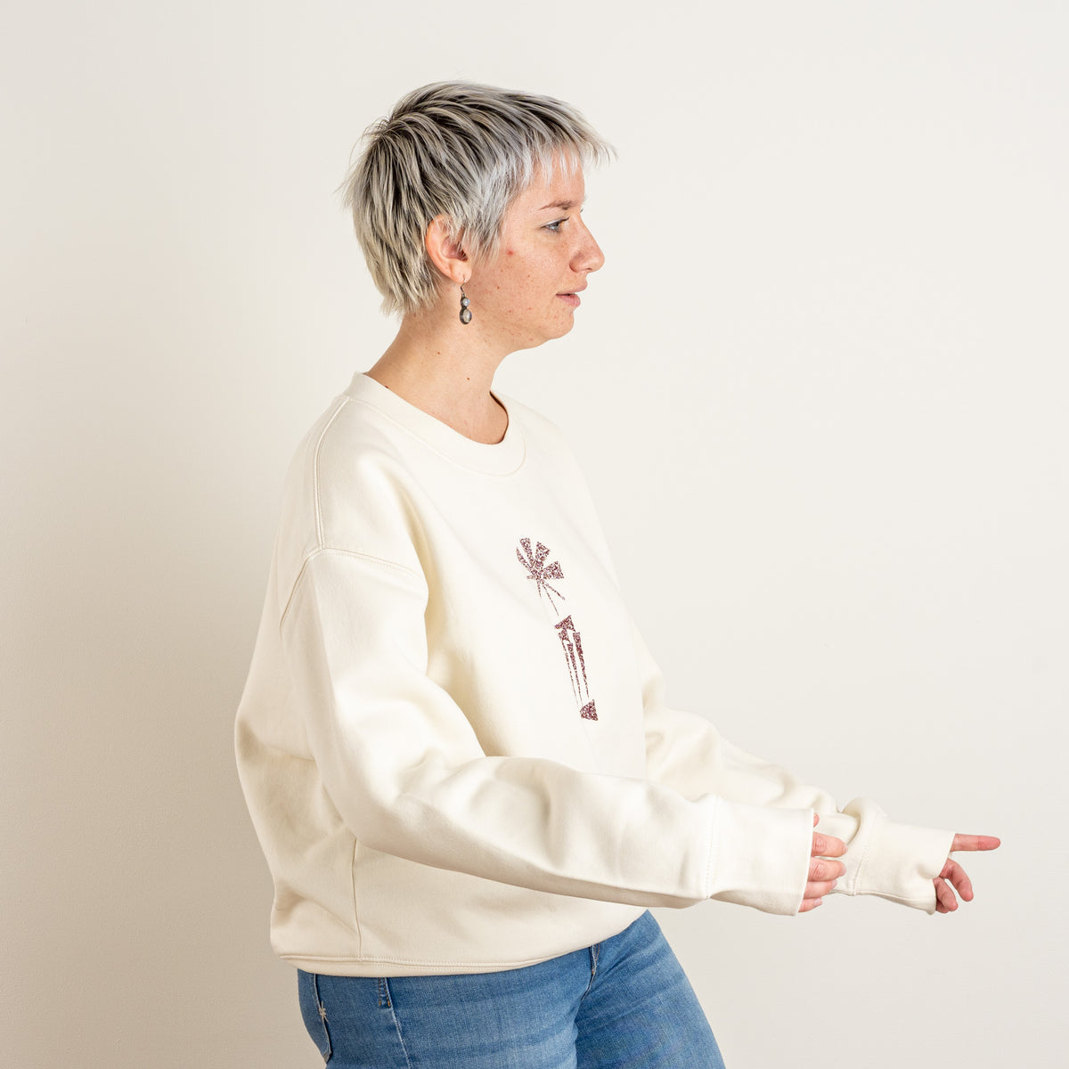 Side pose showing the relaxed fit of the ecru Star and House sweatshirt