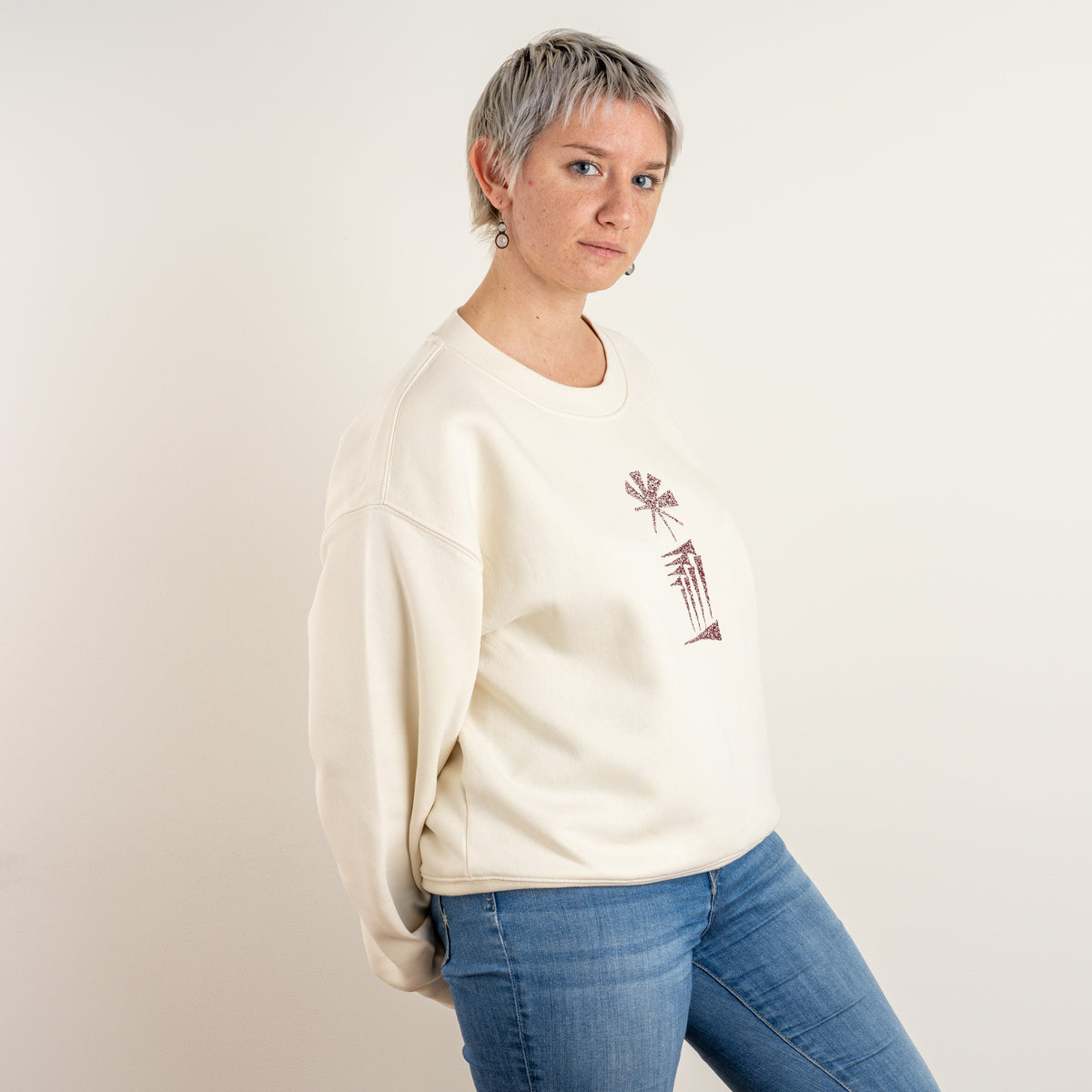 Side view of the ecru Star and House embroidered sweatshirt on a model
