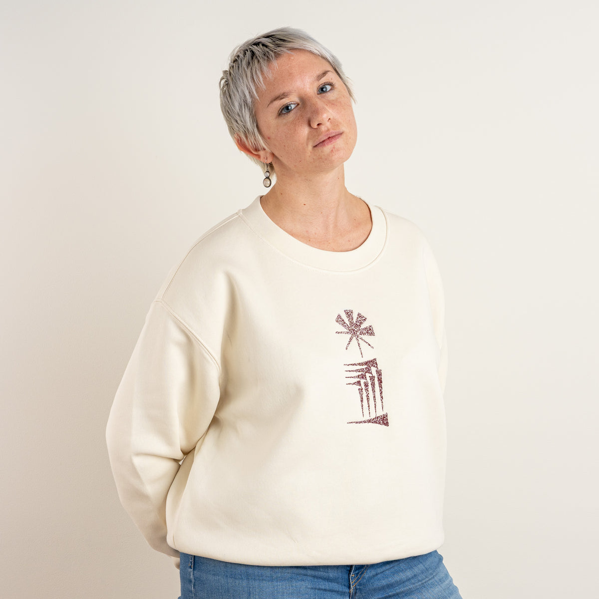 Model wearing the ecru Star and House embroidered sweatshirt, three-quarter front view