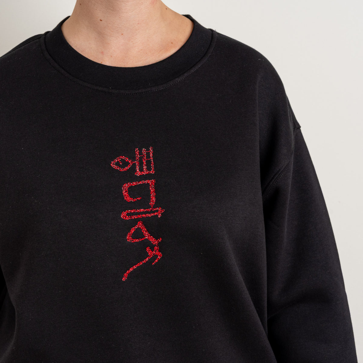 Close-up of the red Papyrus embroidery on the black sweatshirt