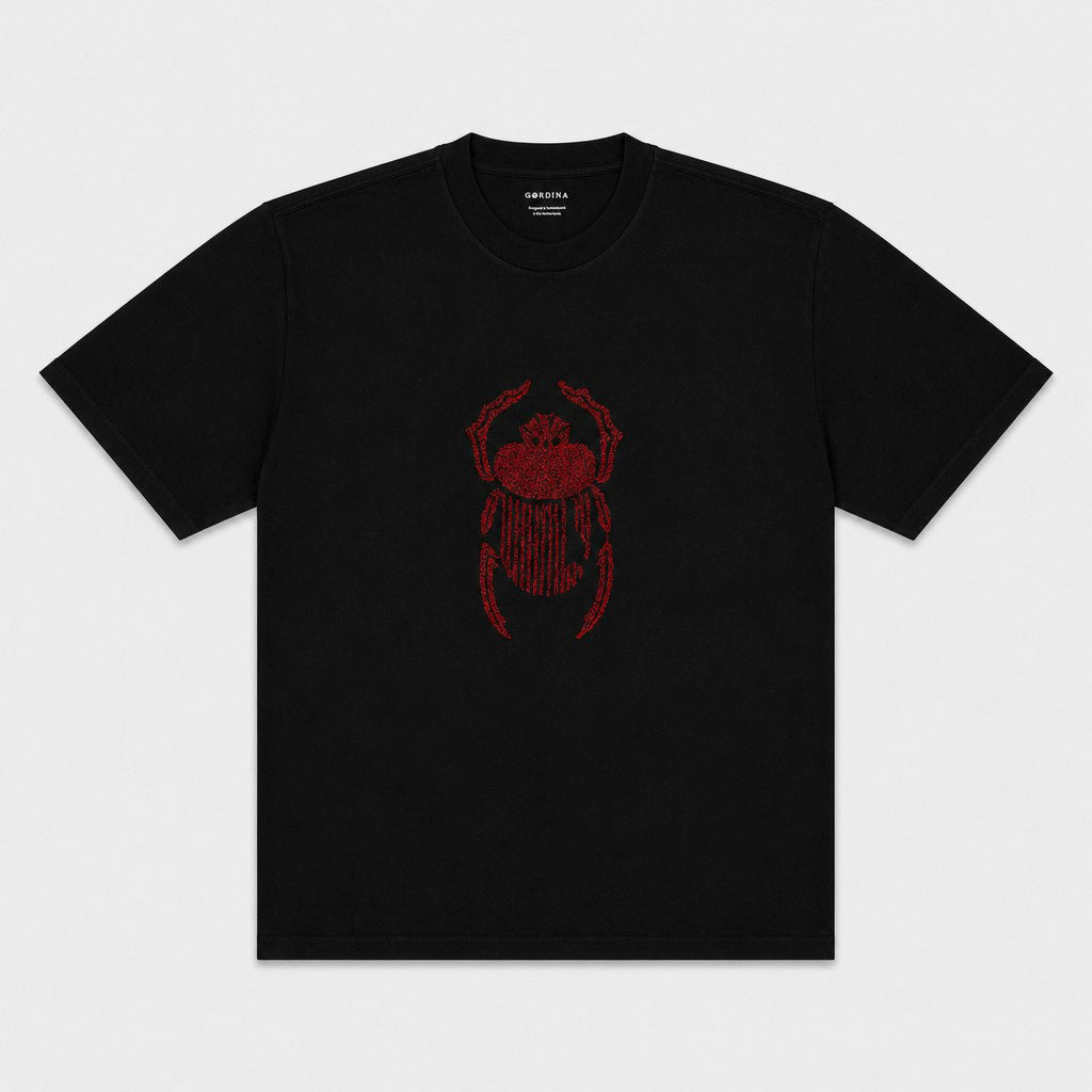 Front flat lay of the black Gordina Scarab T-shirt with centered red scarab embroidery.