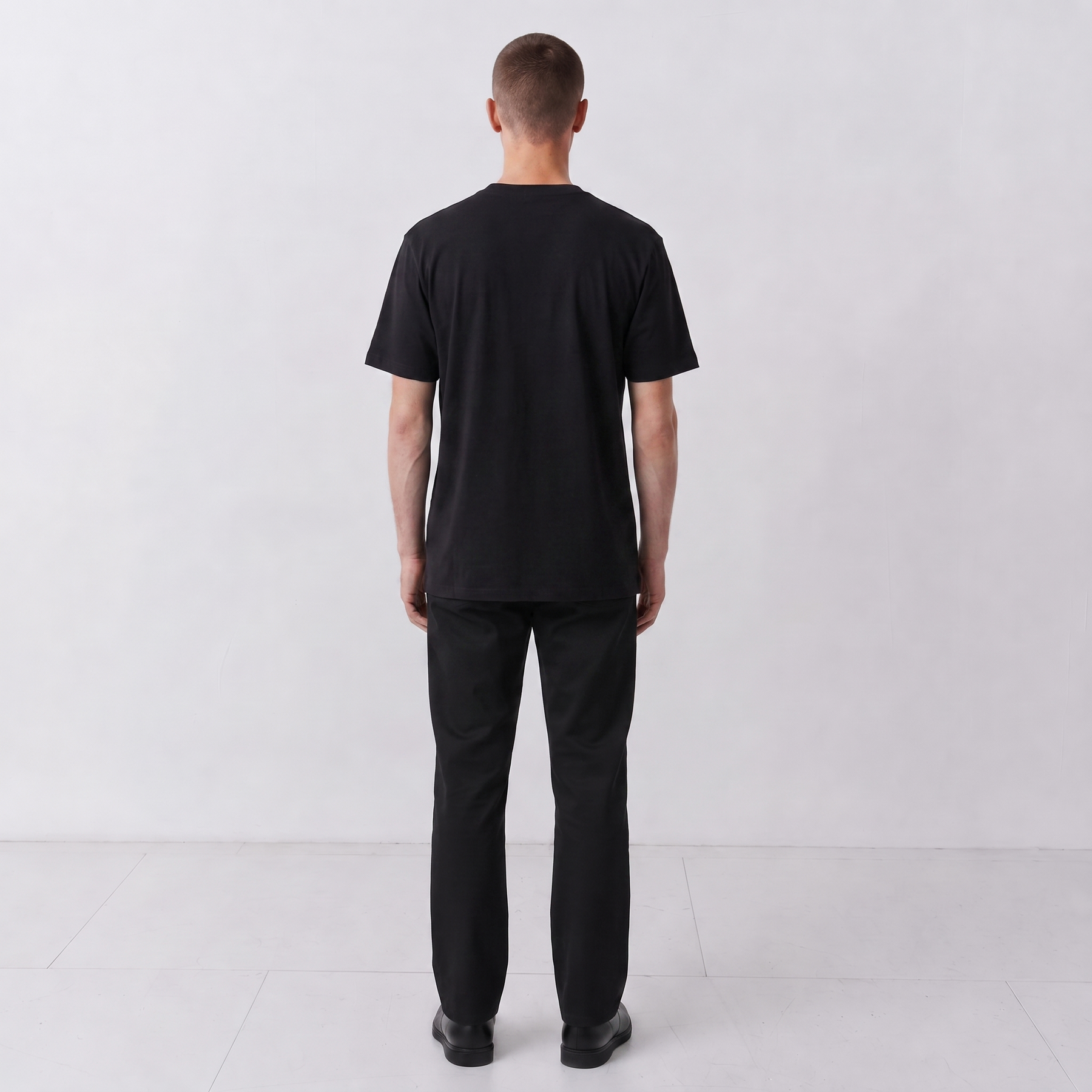Back view of a model wearing the plain-back black Gordina Scarab T-shirt.