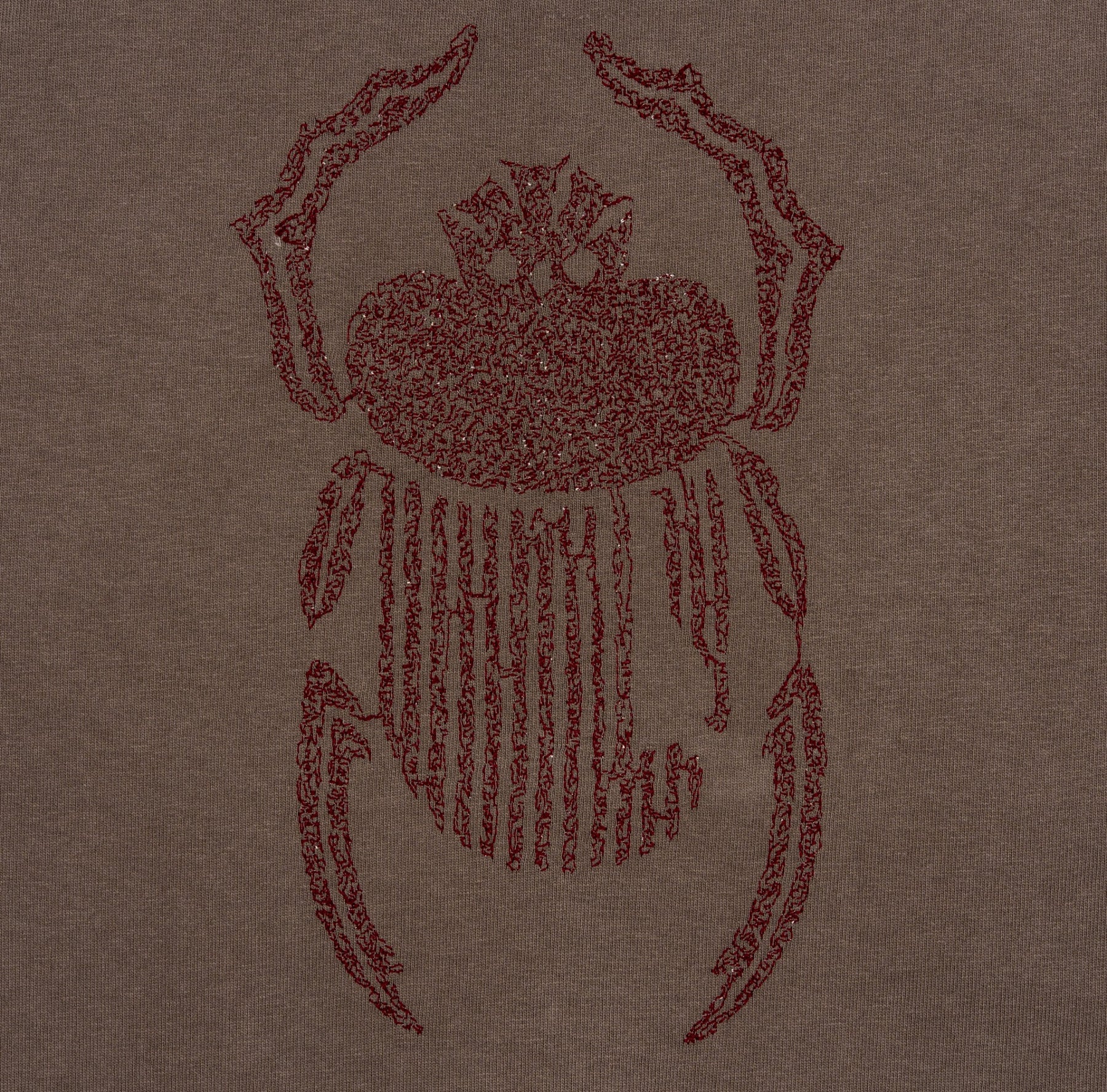 Close-up of burgundy scarab embroidery on the Gordina grey heavyweight cotton T-shirt.