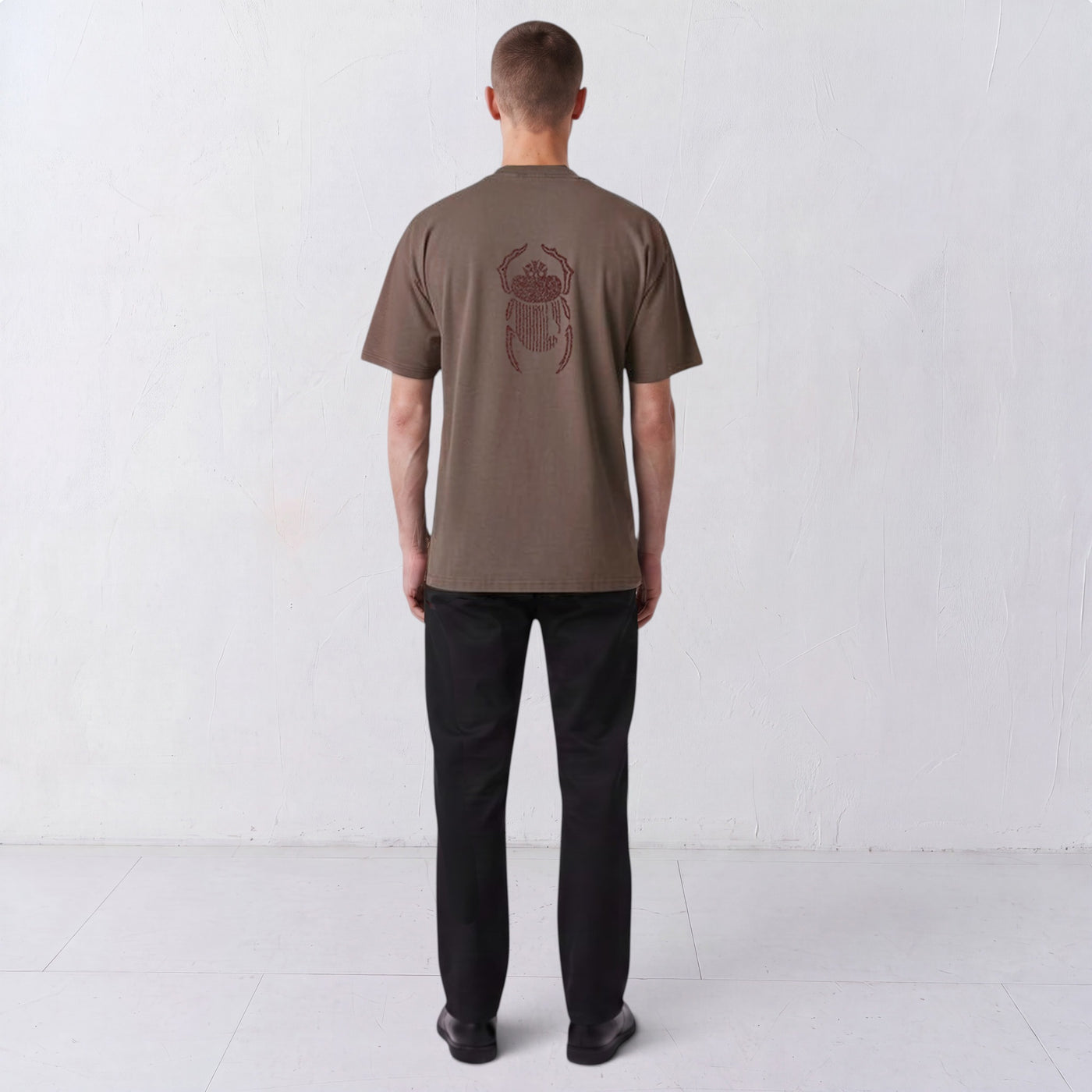 Back view of a model wearing the Gordina The Scarab grey T-shirt with burgundy scarab embroidery.