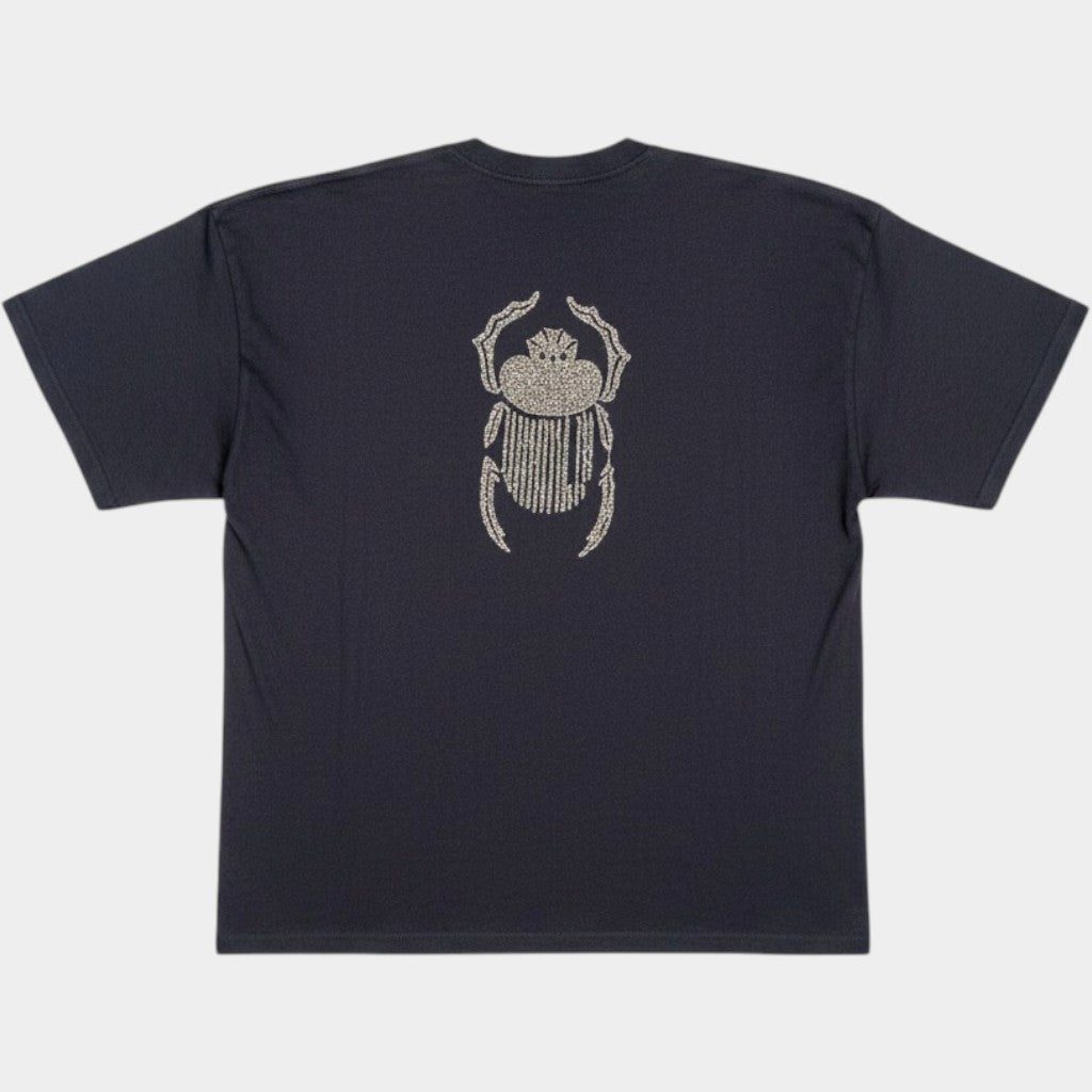 Flat lay of the Gordina The Scarab navy oversized T-shirt with ivory scarab embroidery placed on the back.