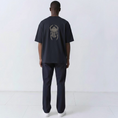 Load image into Gallery viewer, Back view of a model wearing the Gordina The Scarab navy oversized T-shirt with ivory scarab embroidery.
