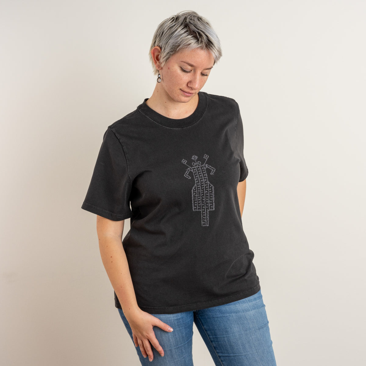 Front view of a model wearing The Ward women’s Faded Coal T-shirt by Gordina, showing the grey horse-and-rider embroidery on the chest.