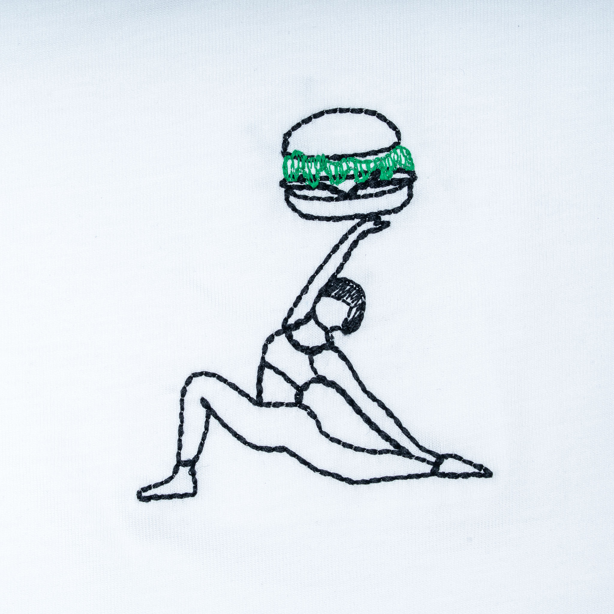 Close-up of white organic cotton t-shirt with yoga figure holding burger embroidery, Gordina
