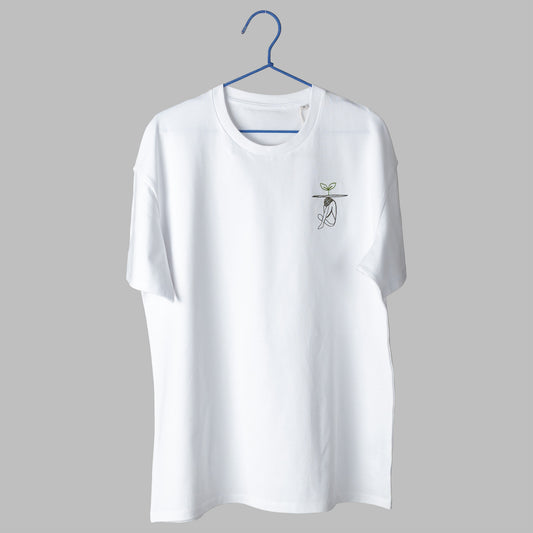 A white t-shirt on a blue wire hanger against a light grey background. It features a small embroidered design on the left chest showing a line-art figure sitting huddled over, with a flat line above them and a small green plant sprouting from the top.