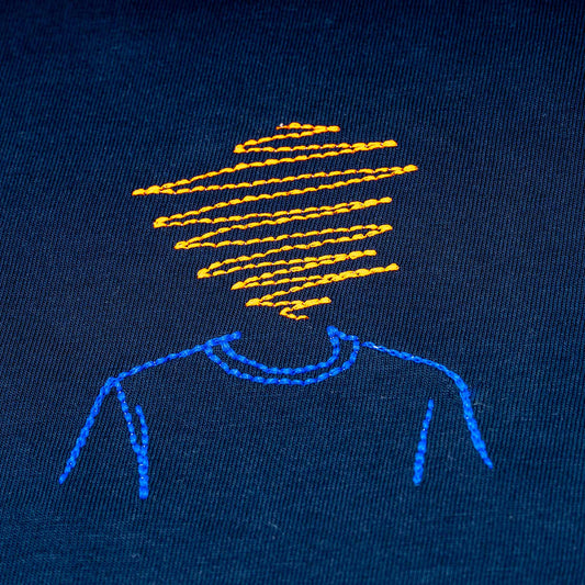 Close-up of navy organic cotton t-shirt with orange and blue abstract head embroidery, Gordina