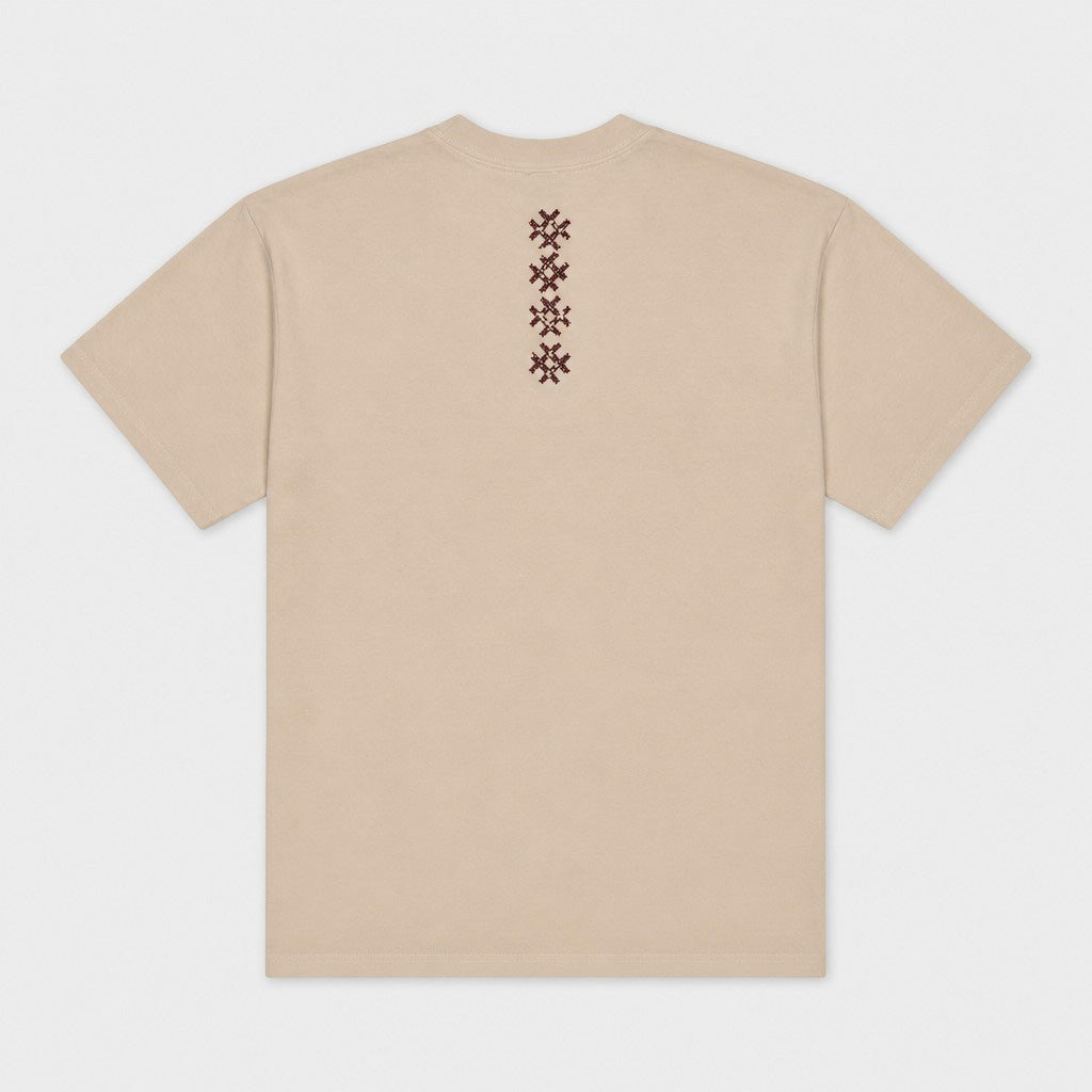 Back flat lay of the beige Gordina Unsigned T-shirt with vertical burgundy cross-stitch embroidery.