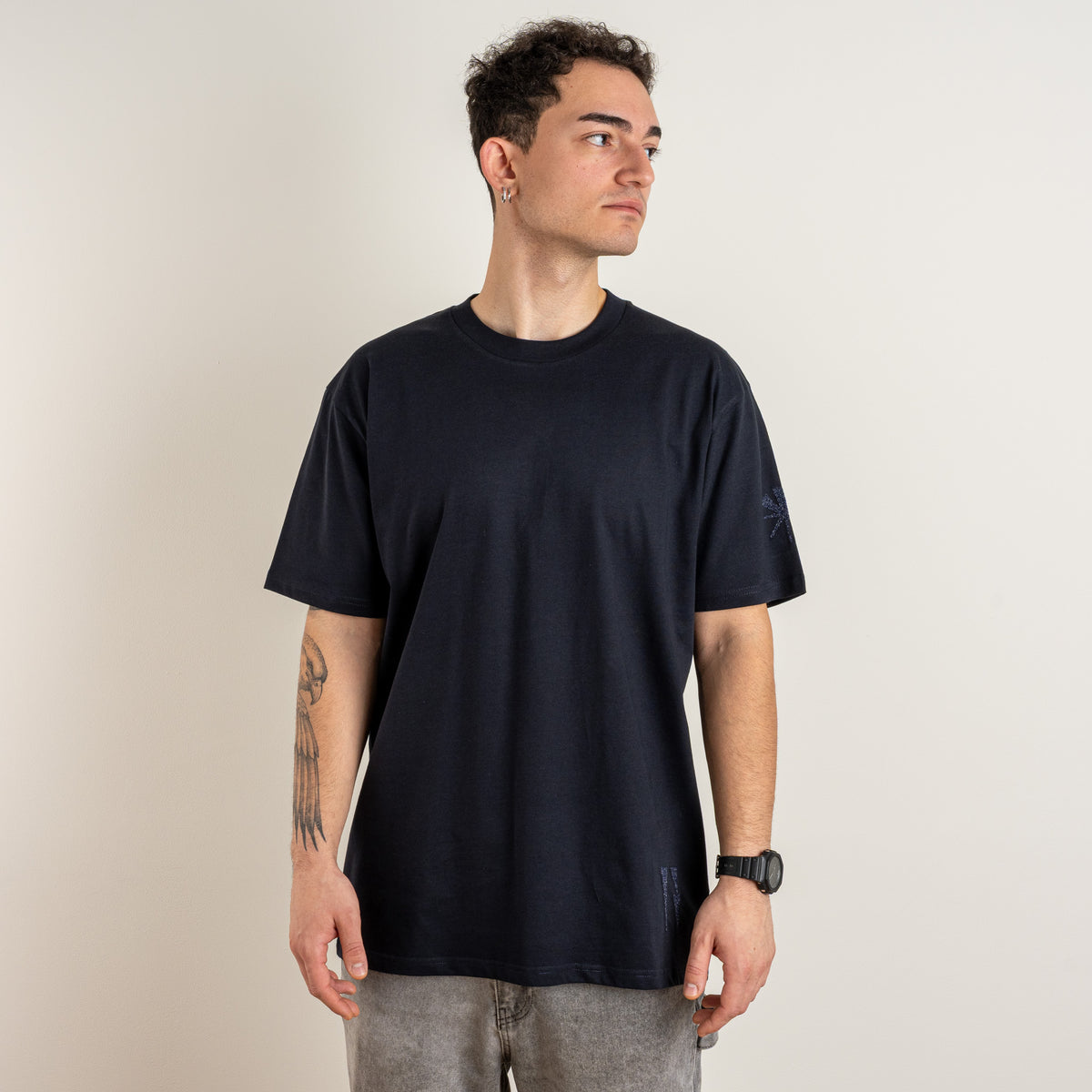 Front view of the navy Water and the Star T-shirt showing blue sleeve star and hem embroidery.